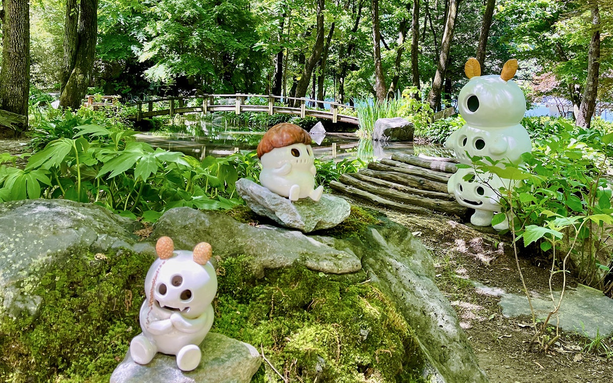 Ceramic figures among bamboo groves and a wooden bridge in Nami Island, South Korea.