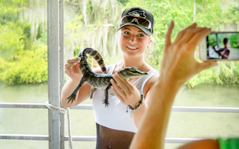 Person holding a baby alligator during a swamp tour near Oak Alley Plantation.