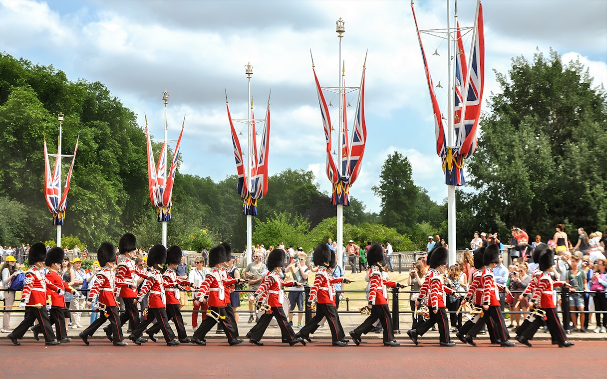 Guards marching in London with Union Jack flags, part of the Magic of London Tour.