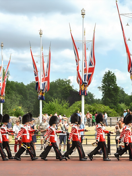 Guards marching in London with Union Jack flags, part of the Magic of London Tour.