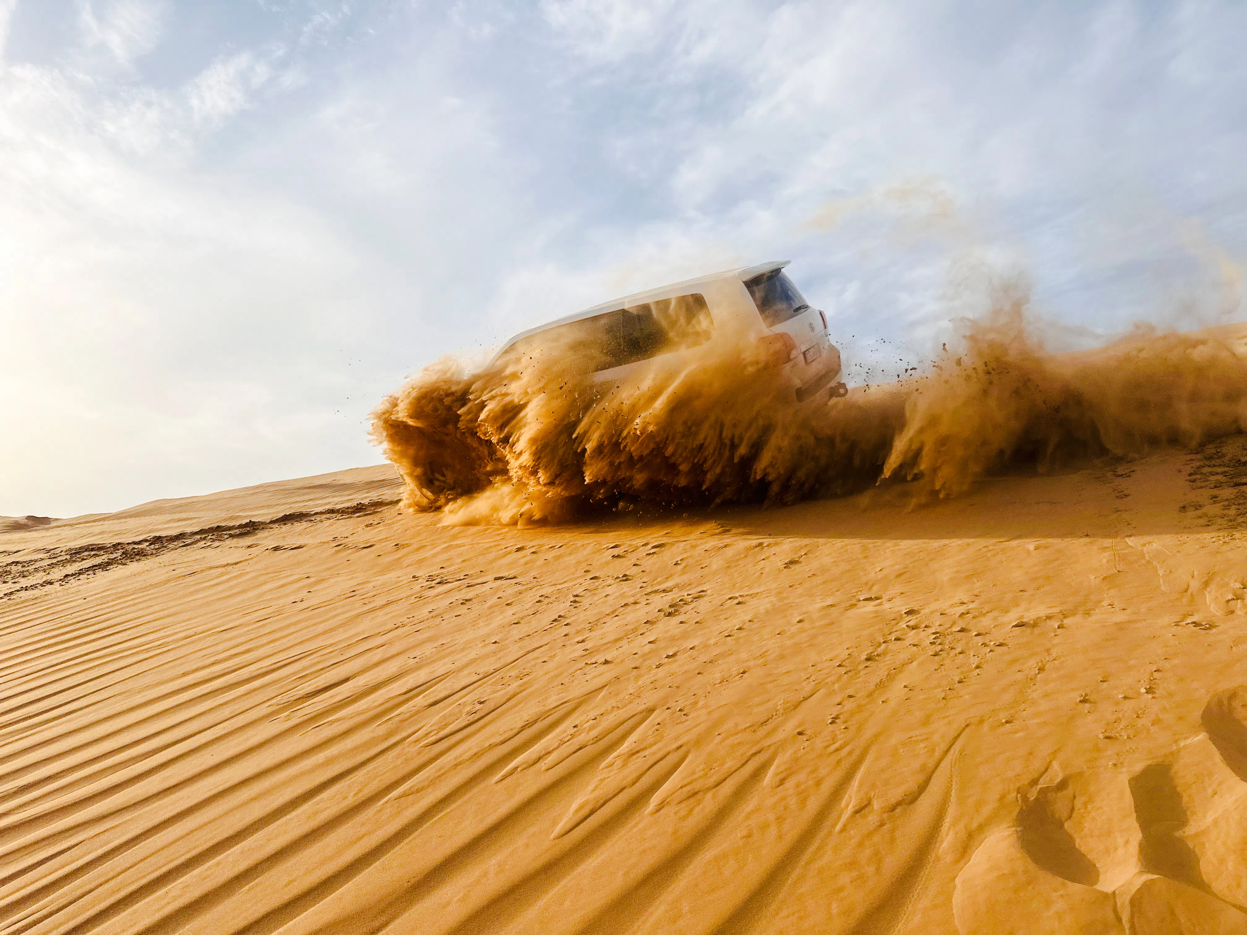 SUV driving through sand dunes during Abu Dhabi desert safari.