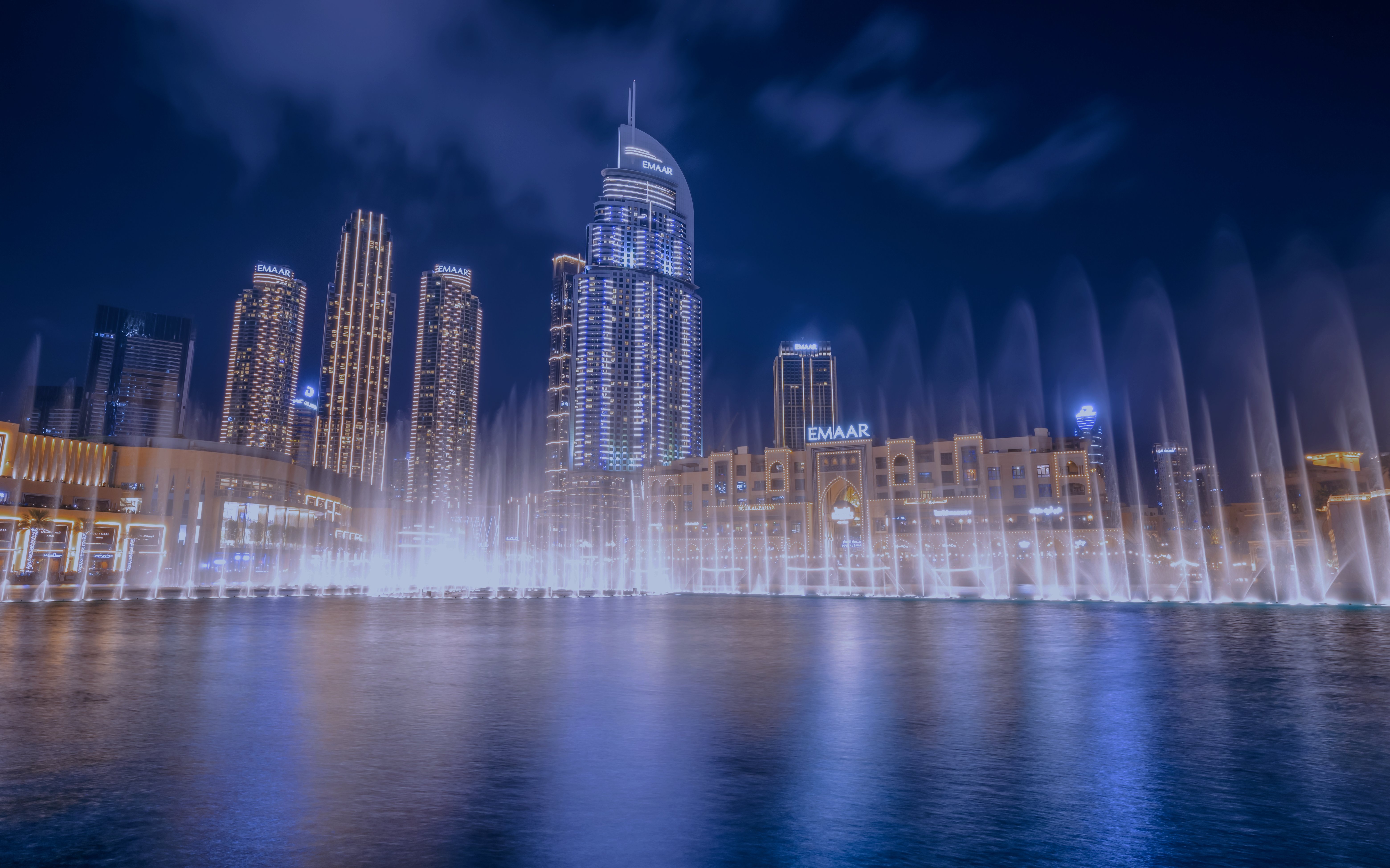 Dubai Fountain show with illuminated skyline at night.
