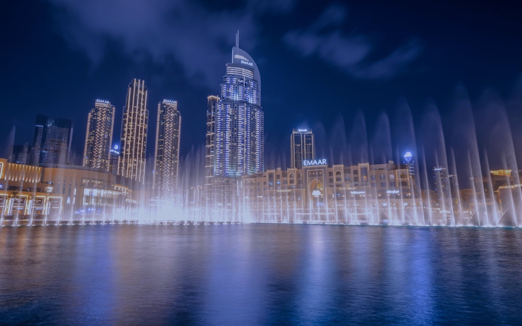 Dubai Fountain show with illuminated skyline at night.