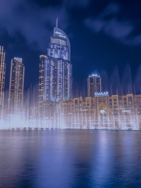 Dubai Fountain show with illuminated skyline at night.