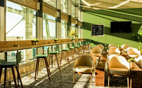 Spacious seating area in The Liffey Lounge at Dublin Airport with large windows and modern decor.