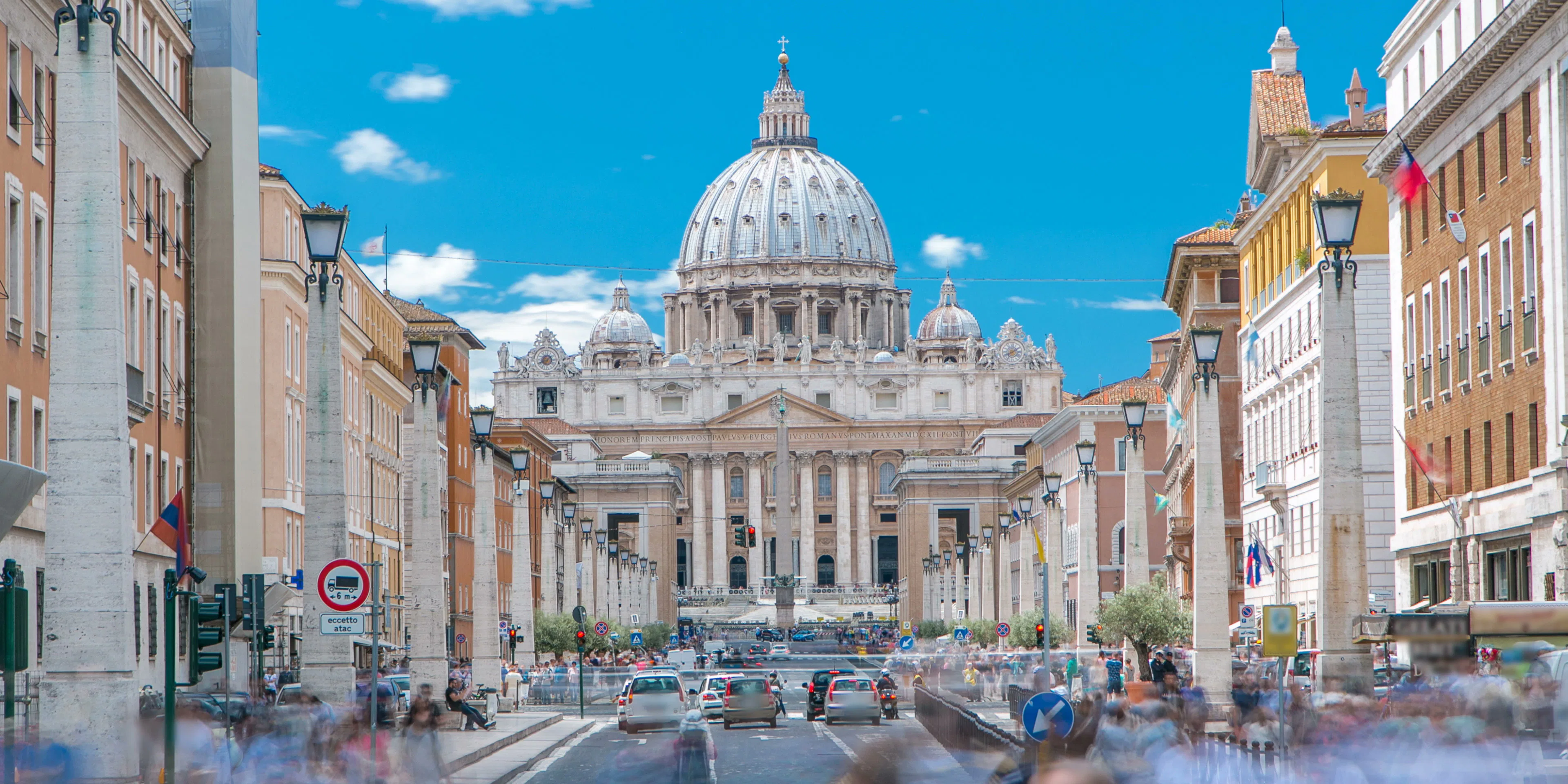 St. Peter's Basilica viewed from a bustling street in Vatican City.