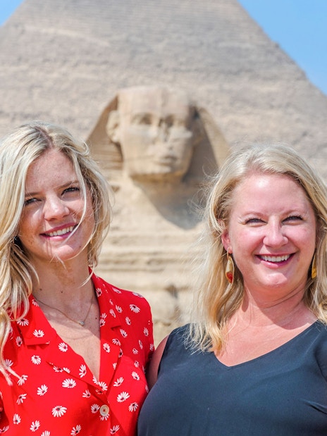 Tourists smiling in front of the Sphinx and Pyramid in Giza, Egypt.