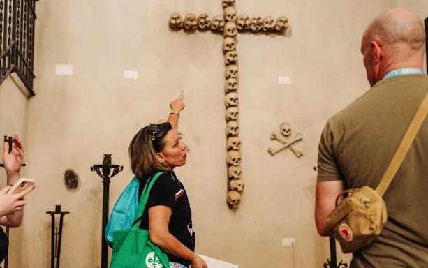 Tourists observing skull cross in Capuchin Crypts, Rome.