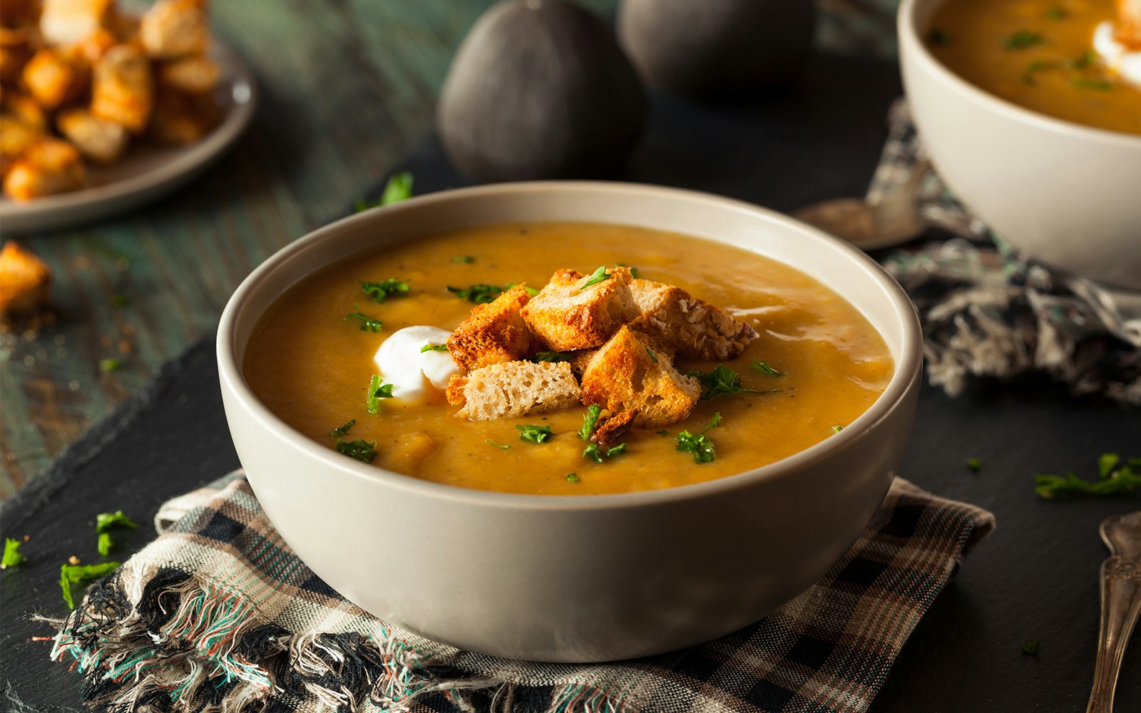 mushroom soup served in a white bowl with a garnish of herbs.