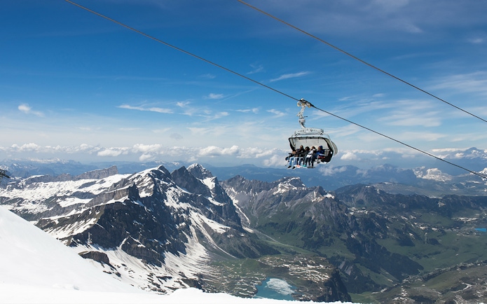 Ice Flyer chairlift over snowy peaks at Mount Titlis, Switzerland.