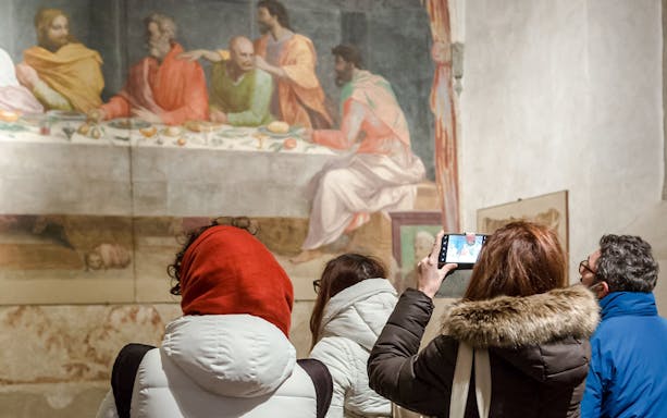 Visitors observing frescoes at Brancacci Chapel, Florence, Italy.