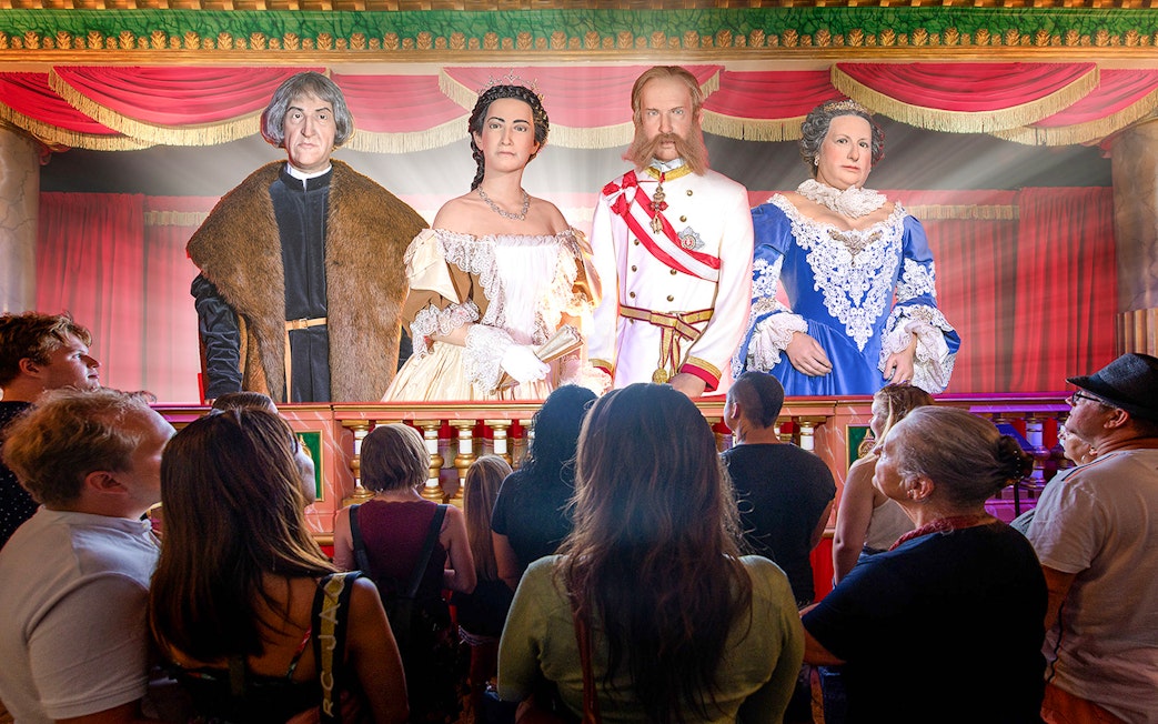Visitors observing historical figures in Time Travel Vienna's virtual reality experience.