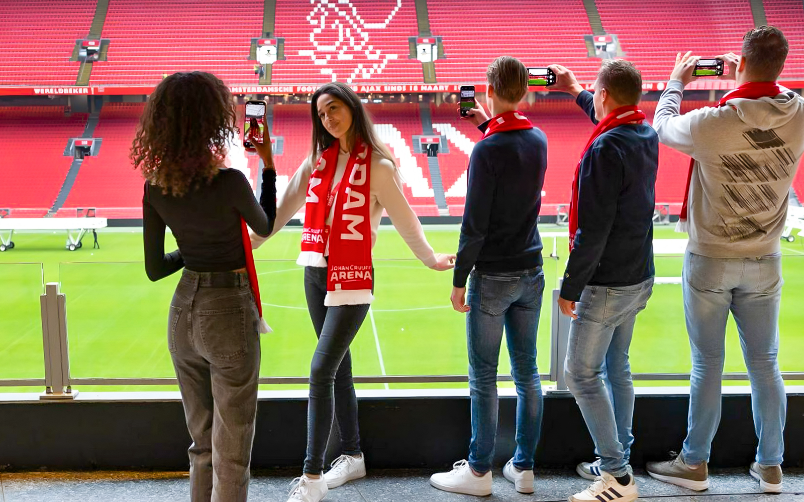 Visitors on Johan Cruijff ArenA VIP tour taking photos with scarves.