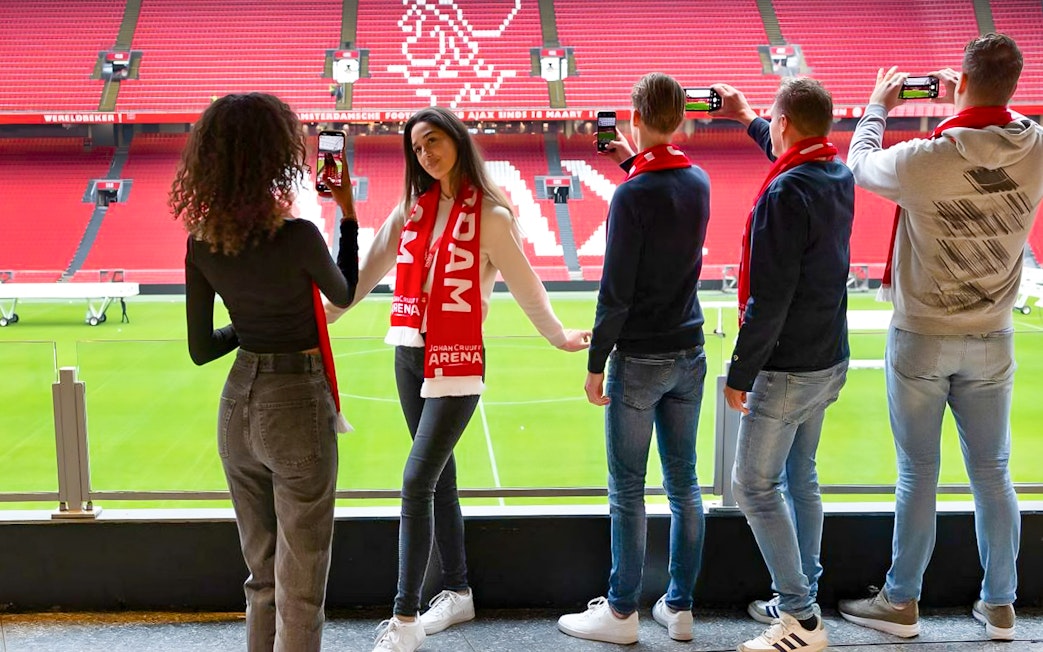 Visitors on Johan Cruijff ArenA VIP tour taking photos with scarves.