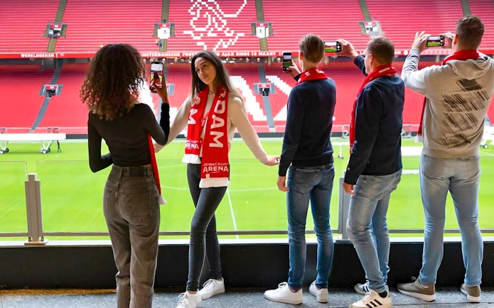 Visitors on Johan Cruijff ArenA VIP tour taking photos with scarves.