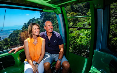 Couple enjoying views from Skyrail Rainforest Cableway on Kuranda tour.