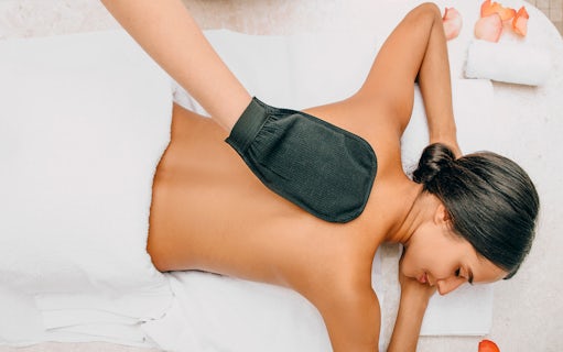 Person receiving a relaxing spa treatment with a hot compress on their back.
