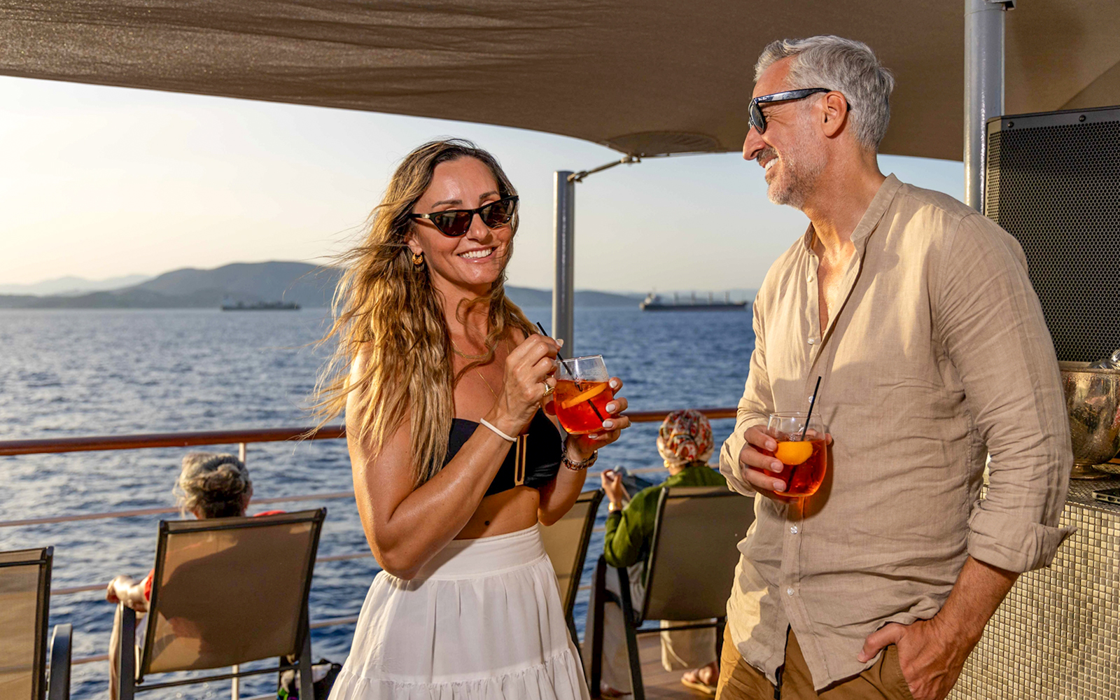 Guests enjoying drinks on Athens Day Cruise with sea view.