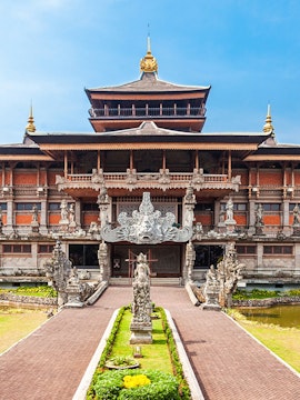 Traditional Indonesian architecture at Taman Mini Indonesia, featuring ornate carvings and statues.