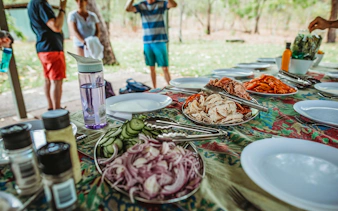 Picnic setup with sliced meats and vegetables on a table during Litchfield Public Day Tour.