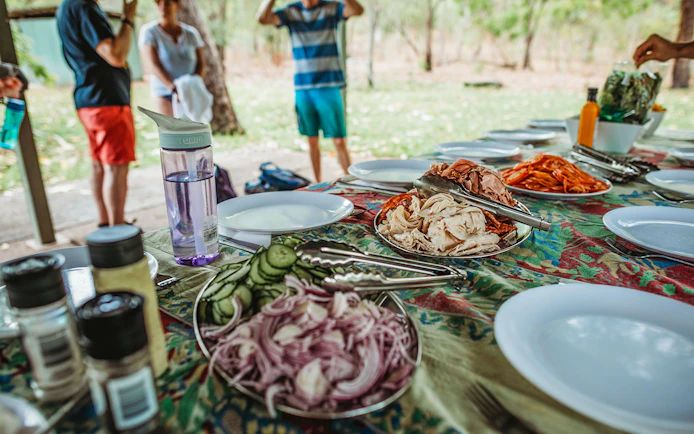 Picnic setup with sliced meats and vegetables on a table during Litchfield Public Day Tour.