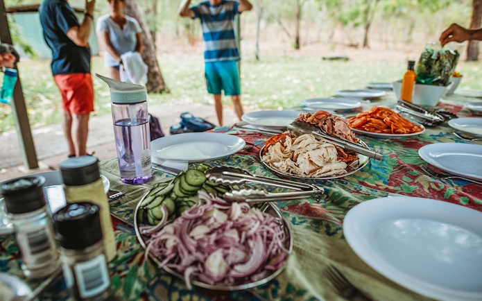 Picnic setup with sliced meats and vegetables on a table during Litchfield Public Day Tour.