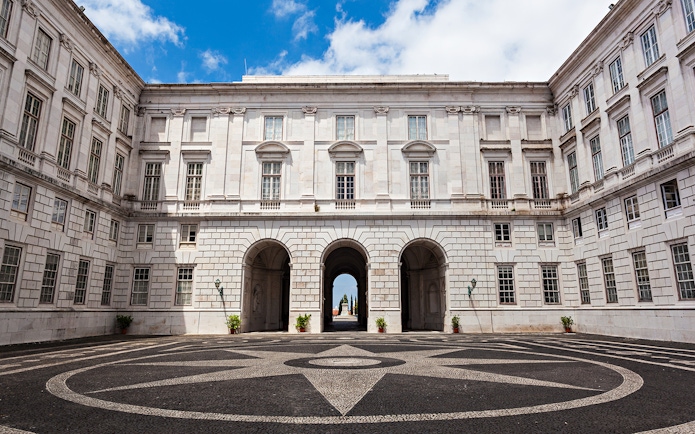 National Palace of Ajuda courtyard with arched entrance and patterned stone pavement.