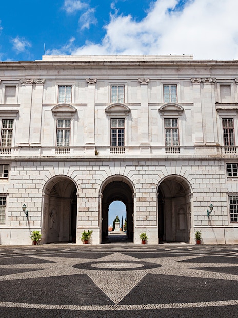 National Palace of Ajuda courtyard with arched entrance and patterned stone pavement.