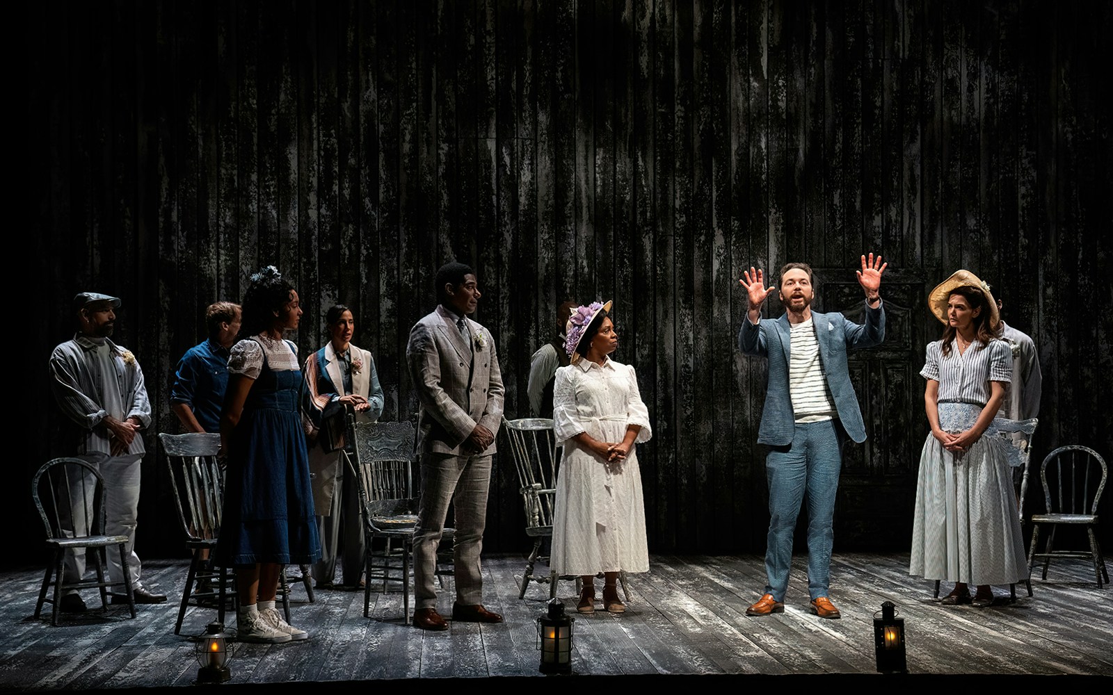 Cast performing "Our Town" on stage with period costumes and minimal set design.