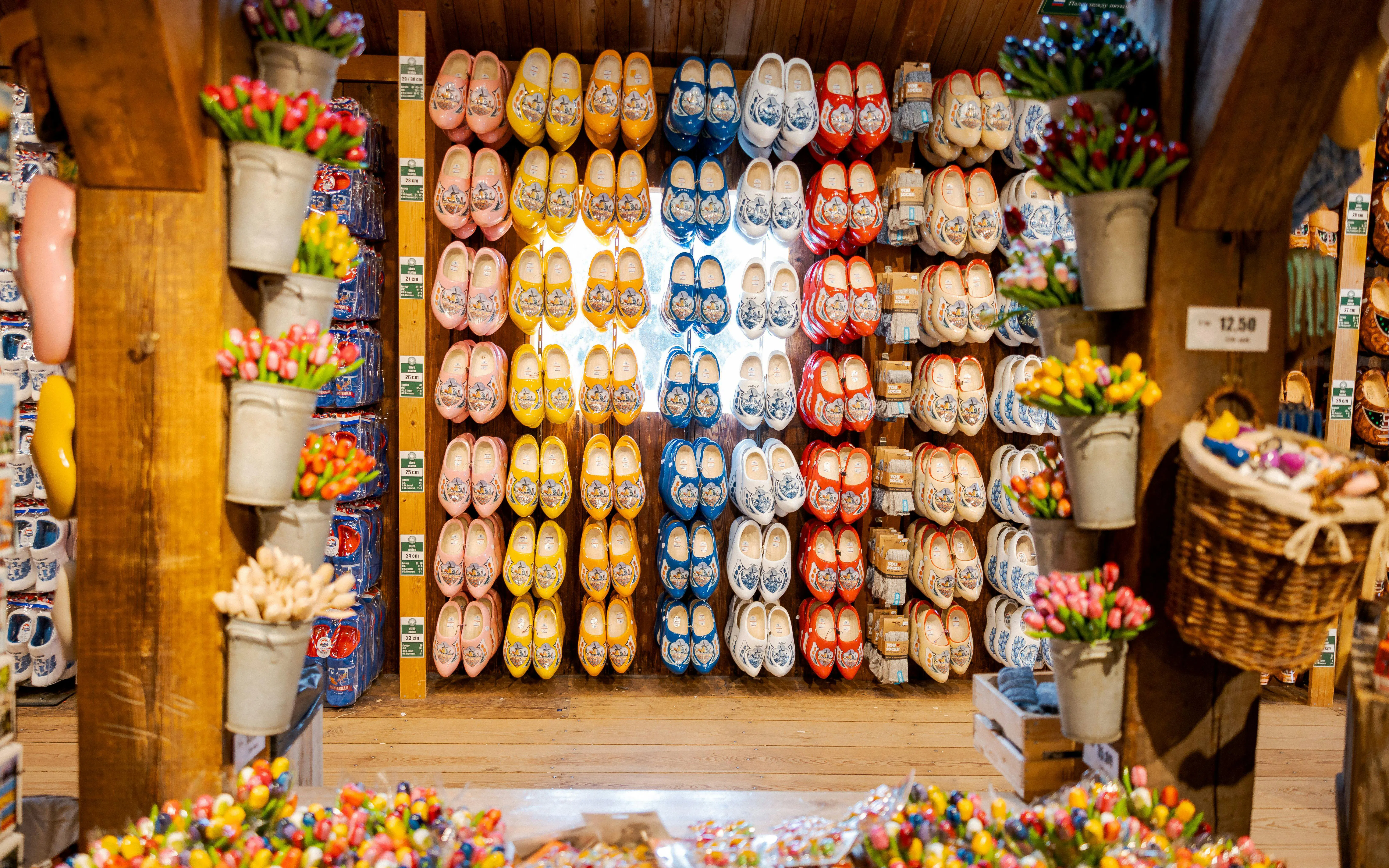 Traditional Dutch wooden shoes displayed in a shop with colorful tulips.