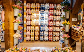 Traditional Dutch wooden shoes displayed in a shop with colorful tulips.