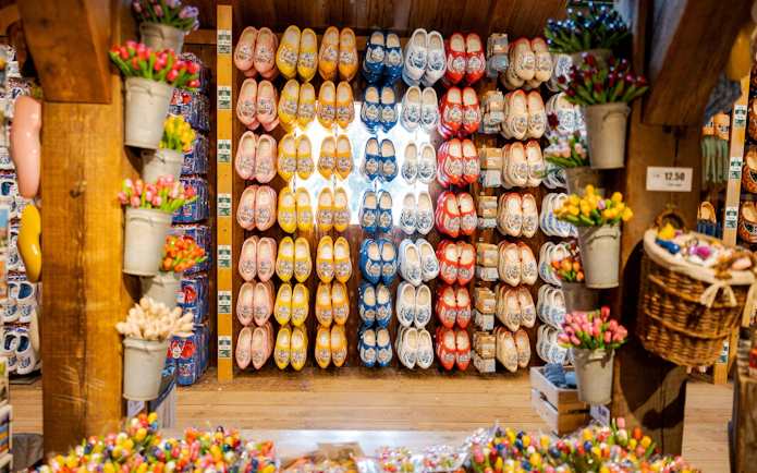 Traditional Dutch wooden shoes displayed in a shop with colorful tulips.