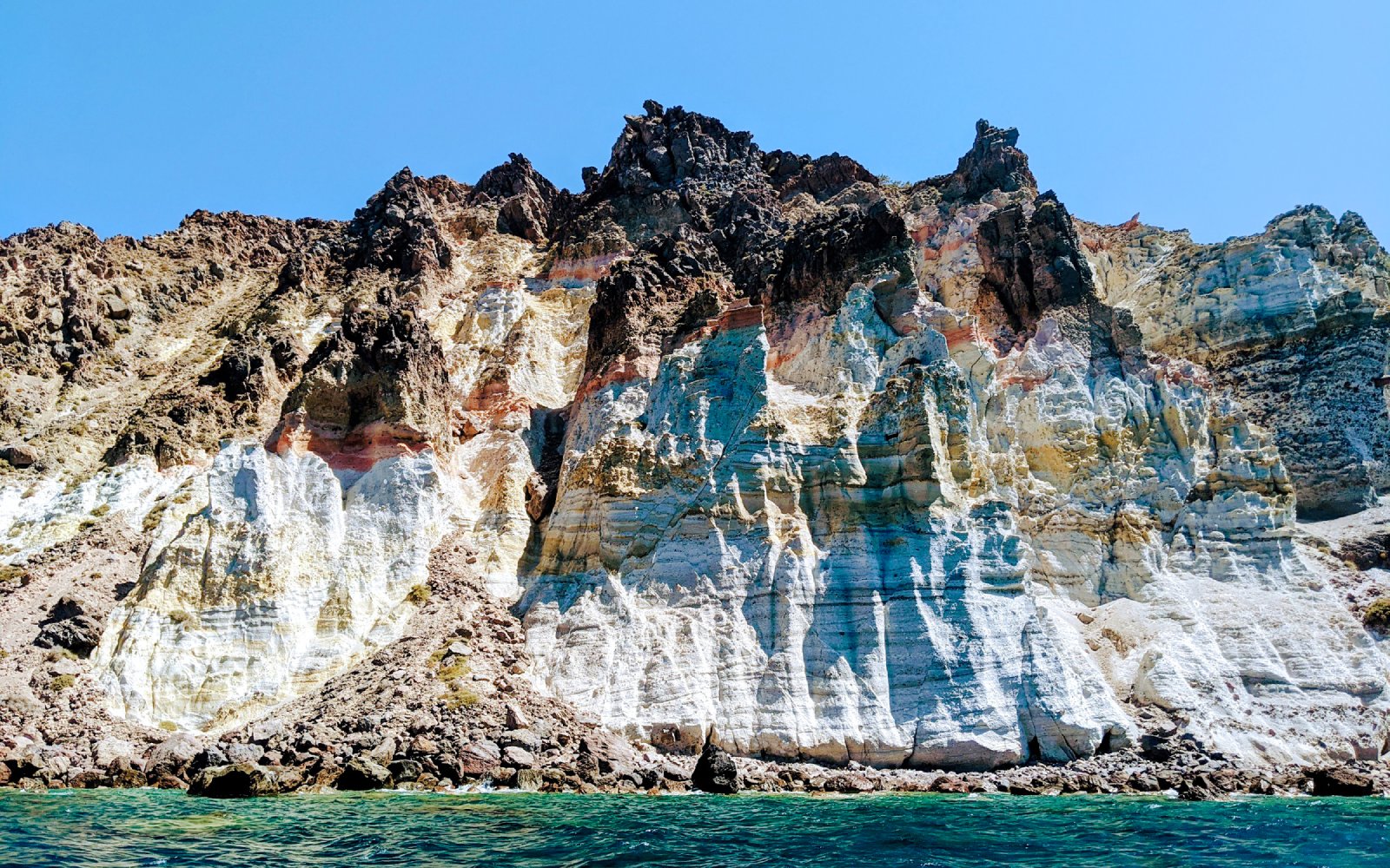 Volcanic cliffs of the Santorini caldera with layered rock formations in Greece.