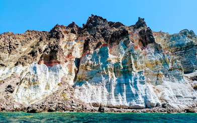 Volcanic cliffs of the Santorini caldera with layered rock formations in Greece.