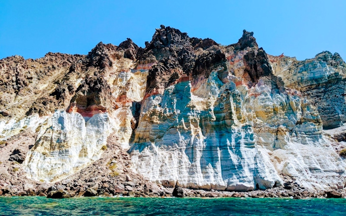 Volcanic cliffs of the Santorini caldera with layered rock formations in Greece.