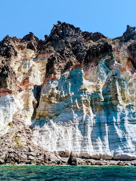 Volcanic cliffs of the Santorini caldera with layered rock formations in Greece.