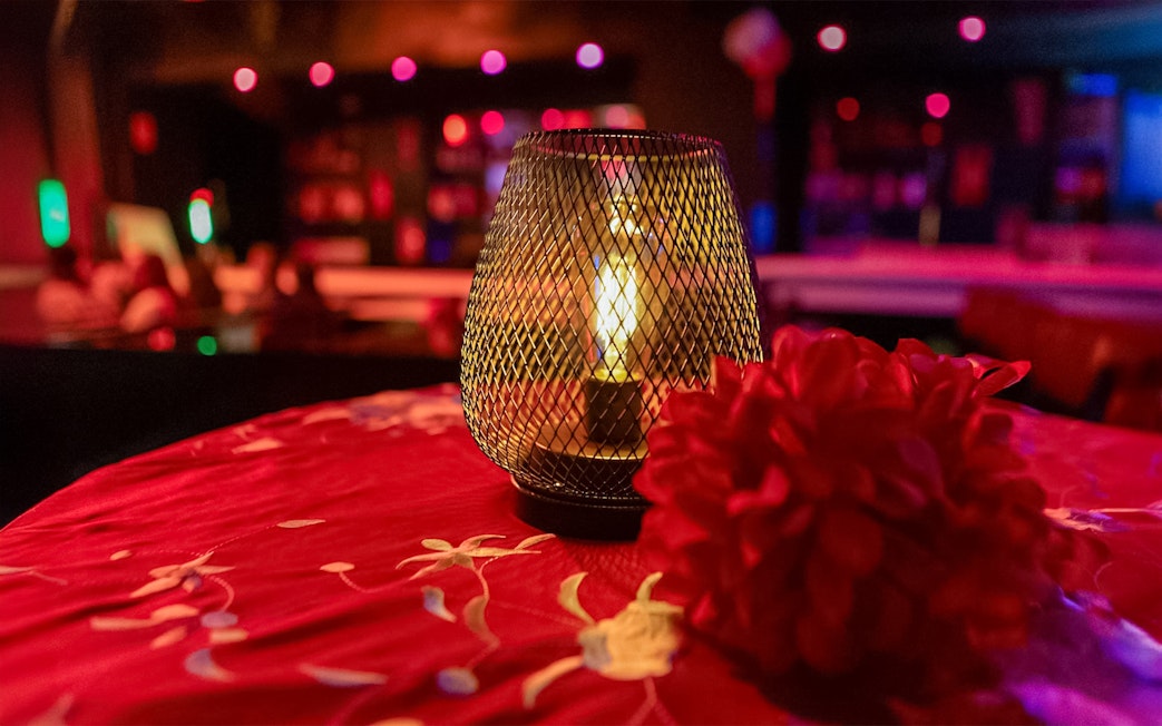 Candlelit table with red flowers at El Duende by Tablao Cordobes Flamenco Show.