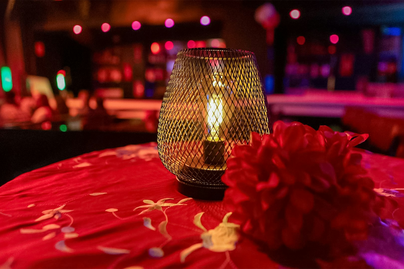 Candlelit table with red flowers at El Duende by Tablao Cordobes Flamenco Show.