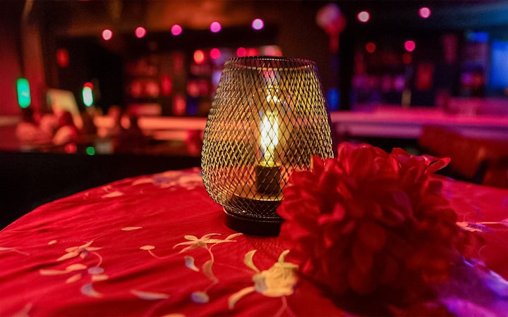 Candlelit table with red flowers at El Duende by Tablao Cordobes Flamenco Show.