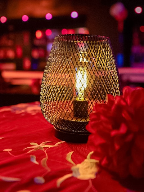 Candlelit table with red flowers at El Duende by Tablao Cordobes Flamenco Show.