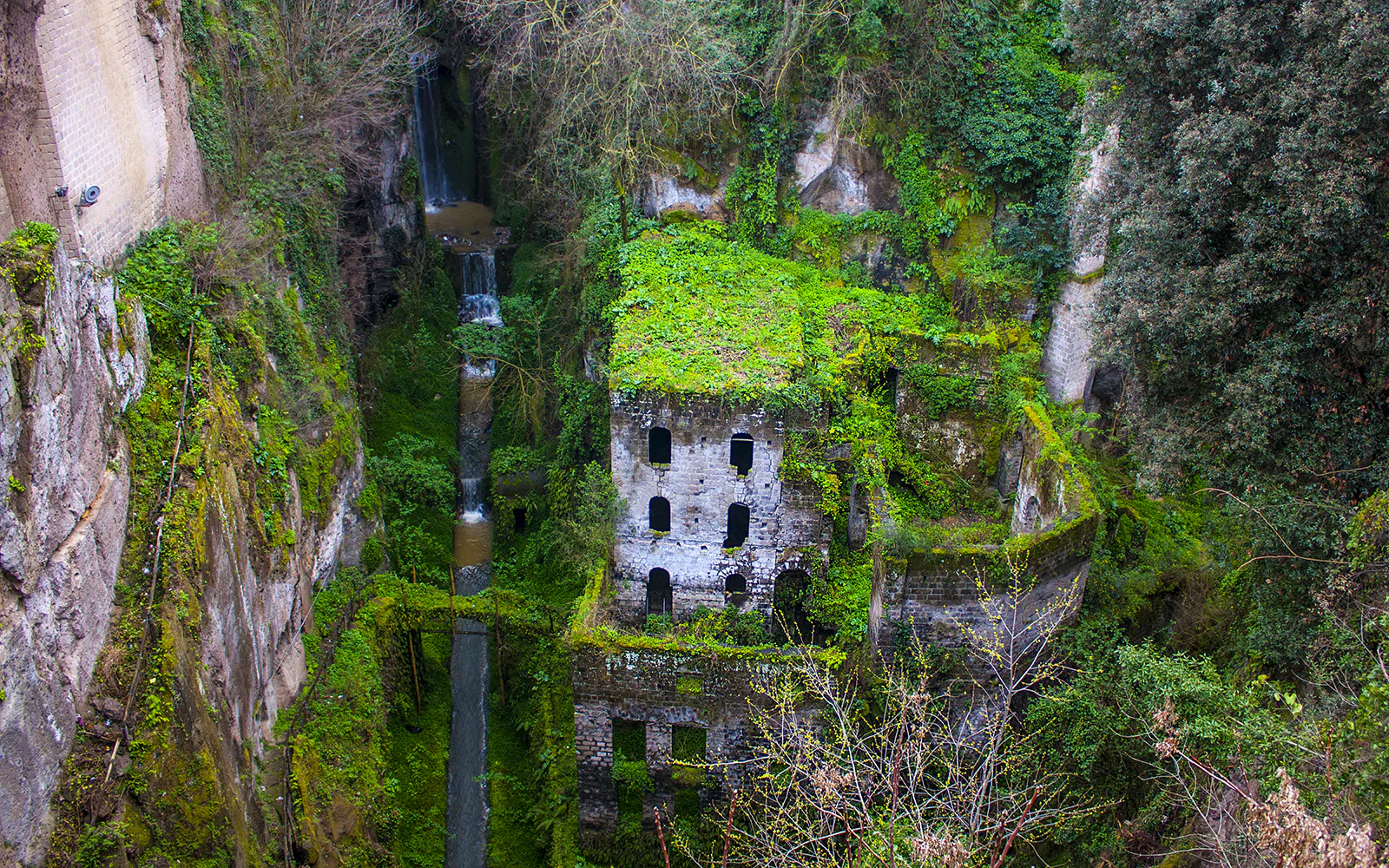 Ancient mill ruins covered in greenery in Sorrento, part of a guided tour from Naples.