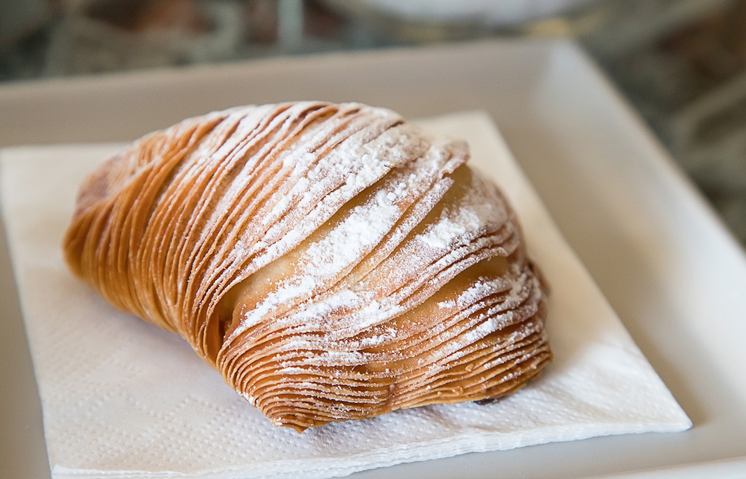 Sfogliatella pastry on a plate in a Naples café.