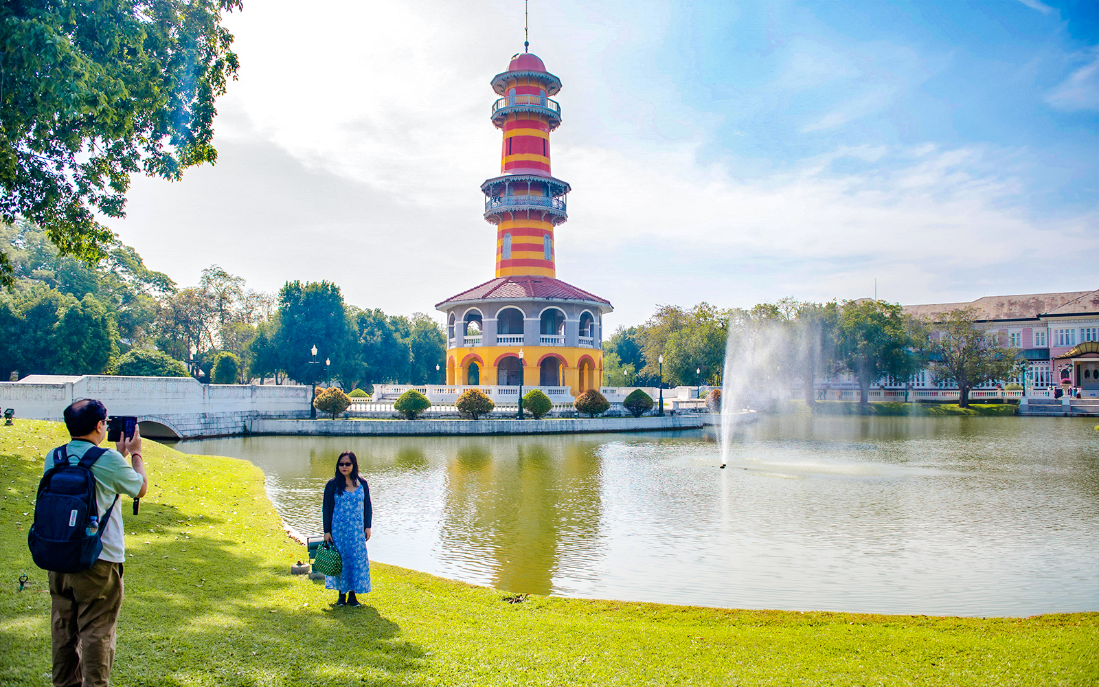 Ho Withun Thasana tower by a pond at Bang Pa-In Summer Palace, Ayutthaya, with visitors taking photos.