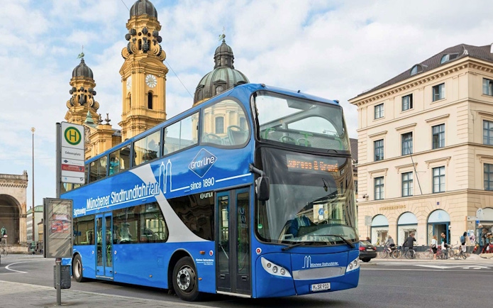 Munich hop-on hop-off bus at Odeonsplatz with Theatinerkirche in background.