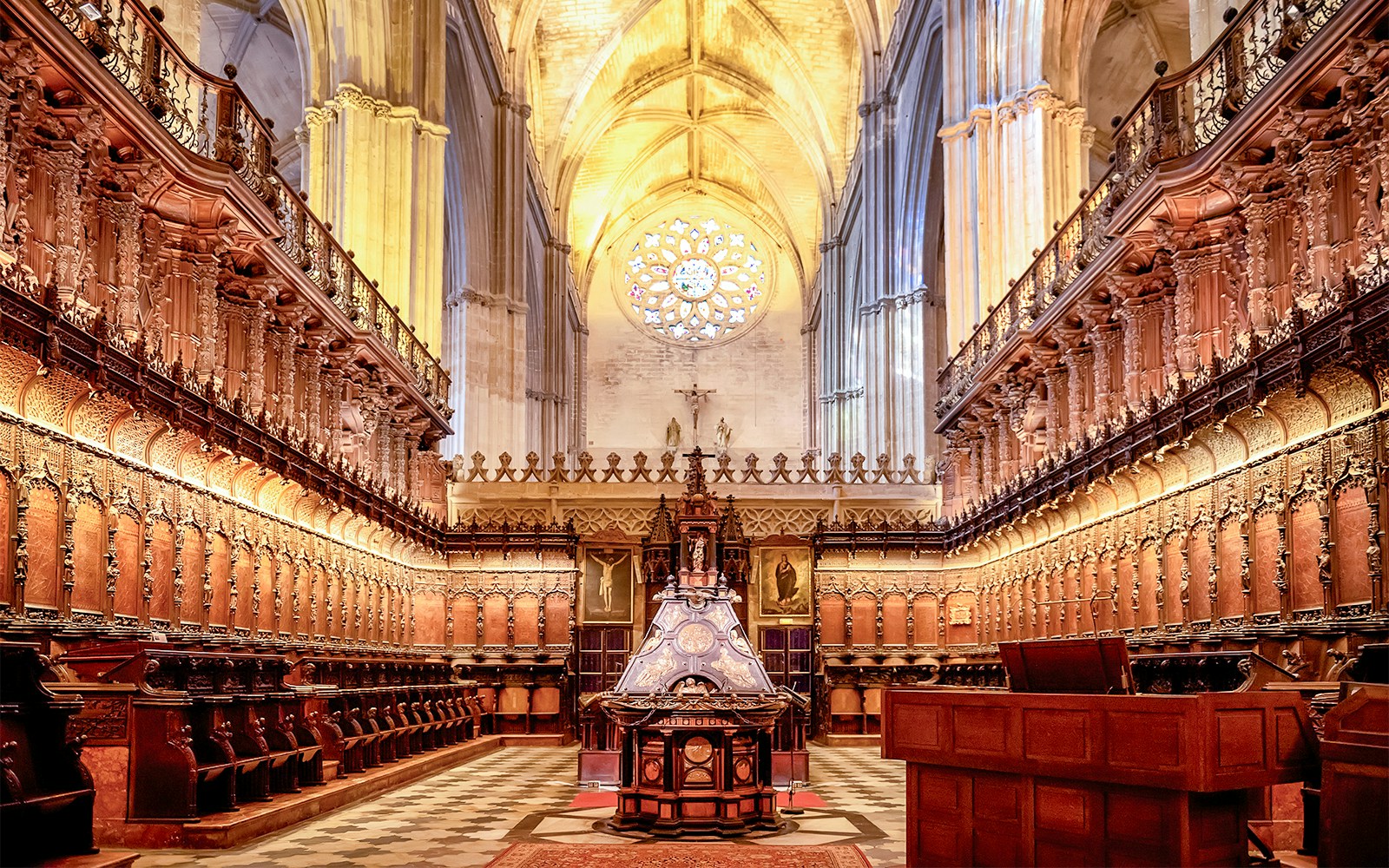 Seville Cathedral interior with ornate Gothic arches and intricate stained glass windows.