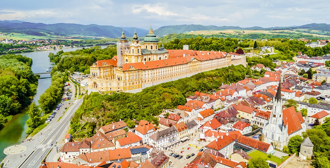 Aerial view of Melk Monastery in Austria with surrounding town and river.