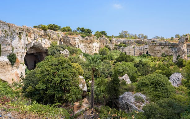 Neapolis Archaeological Park, lush greenery and ancient rock formations, Syracuse.
