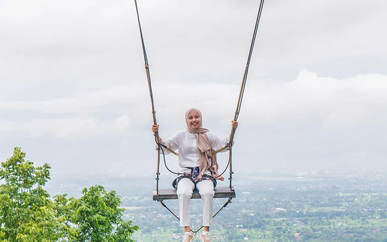 Person on a swing overlooking a scenic view in Dubai, part of All Inclusive Pass.