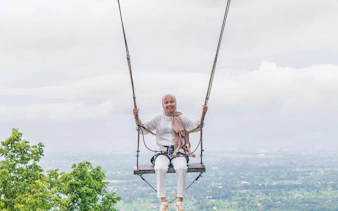 Person on a swing overlooking a scenic view in Dubai, part of All Inclusive Pass.
