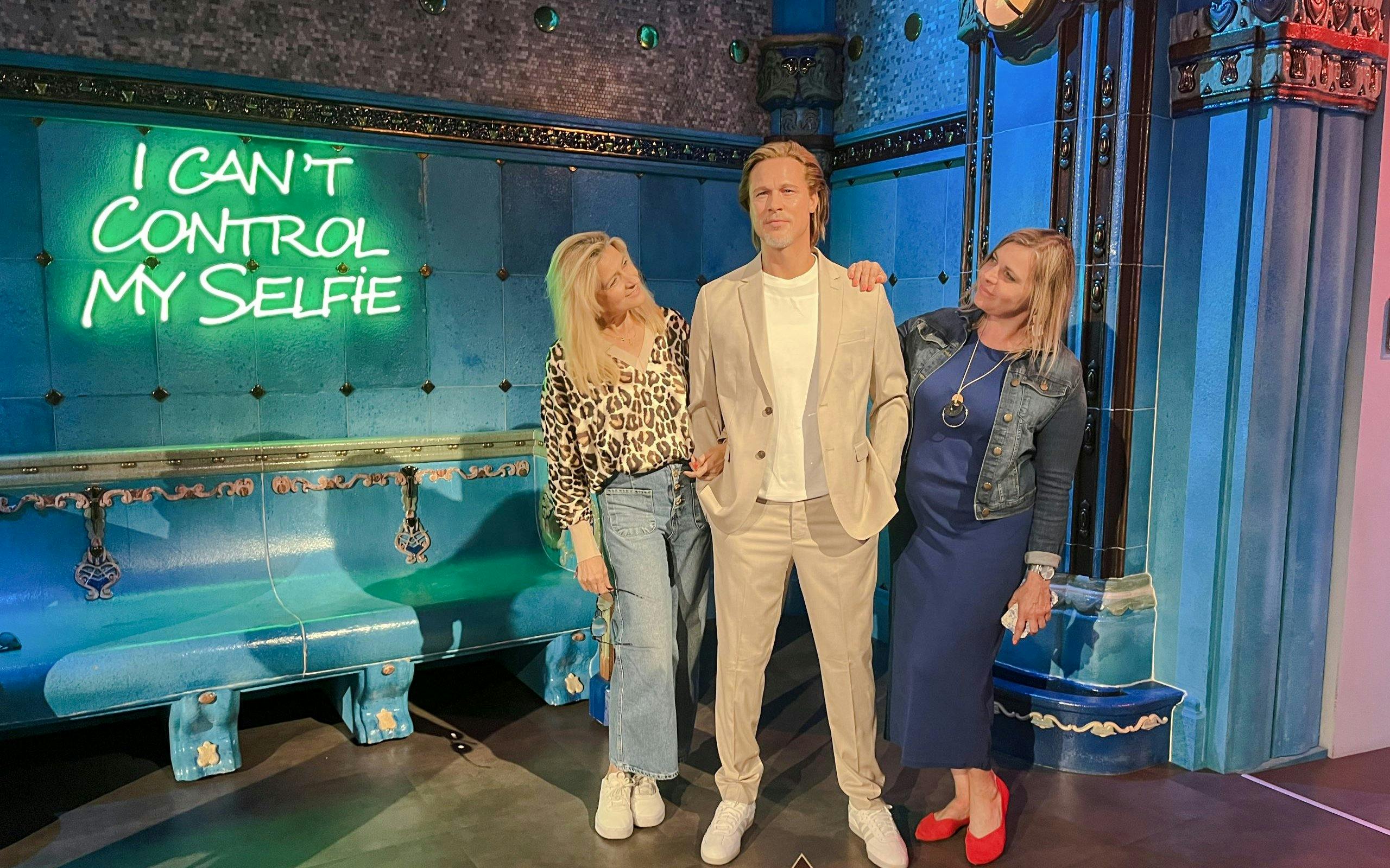 Wax figure at Madame Tussauds Budapest with visitors posing for photos.